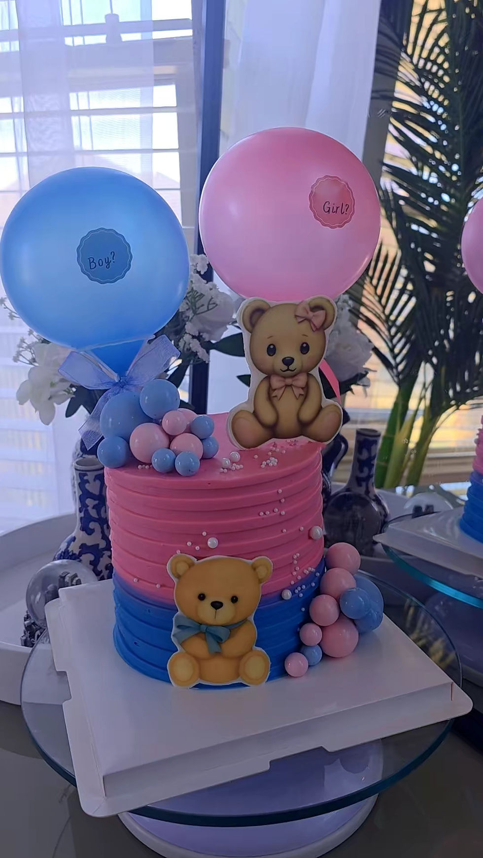 Pink and blue gender reveal cake with teddy bears and balloons