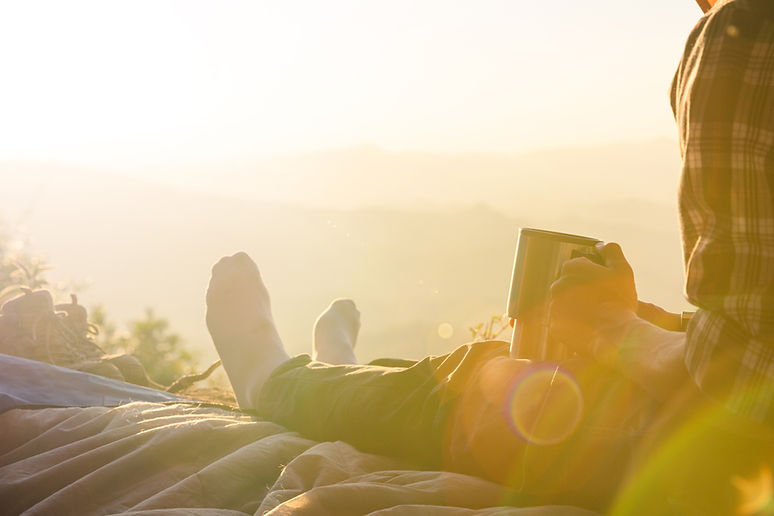 young-man-sitting-in-the-tent-with-holding-coffee-cup_edited.jpg