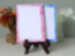 two notepads on a stand, pink unlined and blue lined outer edge