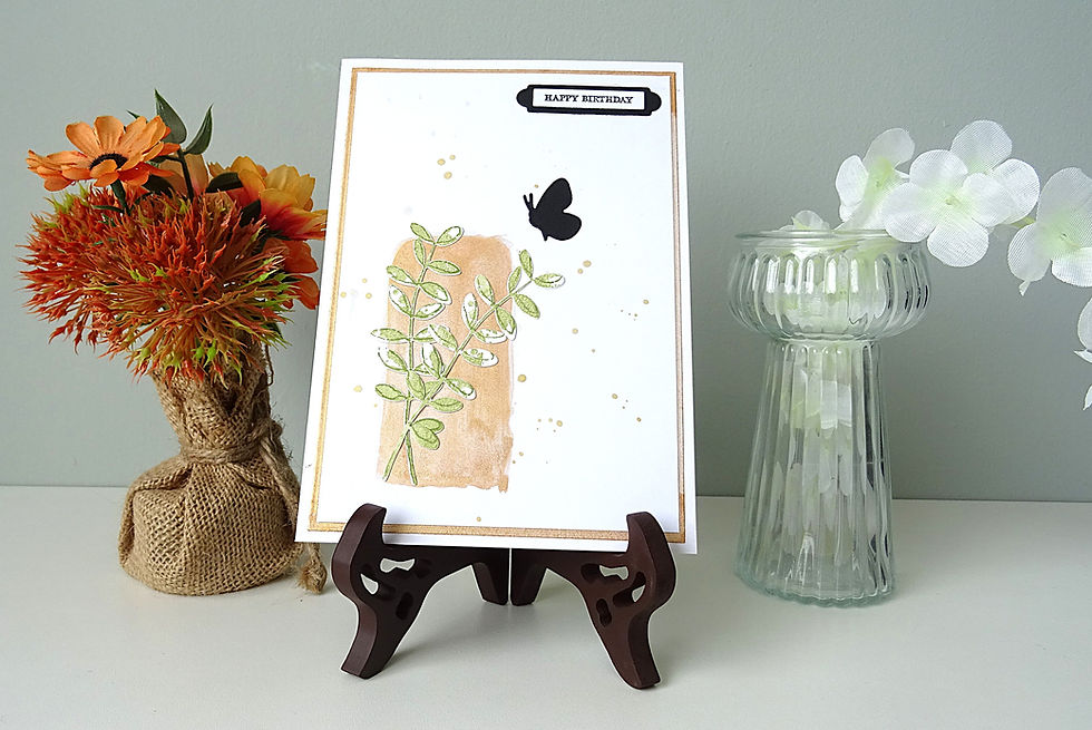 metallic colour block in left hand corner; green leaves over top of block; butterfly; Happy Birthday message top right