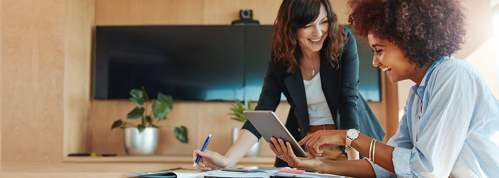 Shot of two businesswoman working together on digital tablet. Creative female executives m