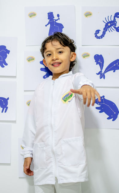 Niño feliz en su fiesta de cumpleaños temática, una experiencia científica para aprender sobre las constelaciones y el universo.