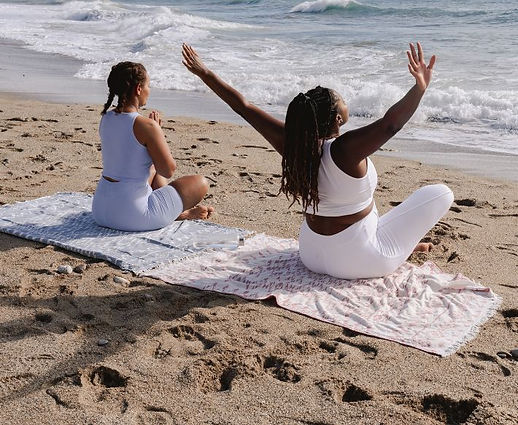 Black women meditating on beach
