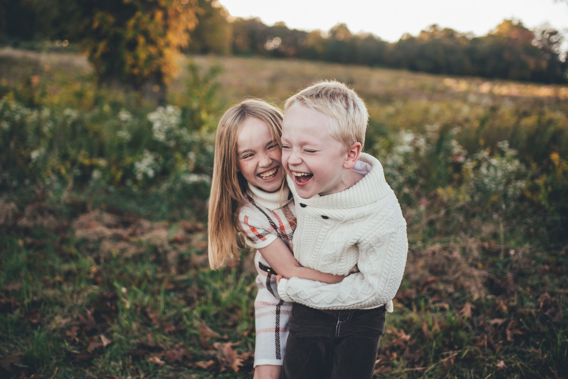 Siblings laughing in a field at Valley Forge National Historical Park in King of Prussia, PA