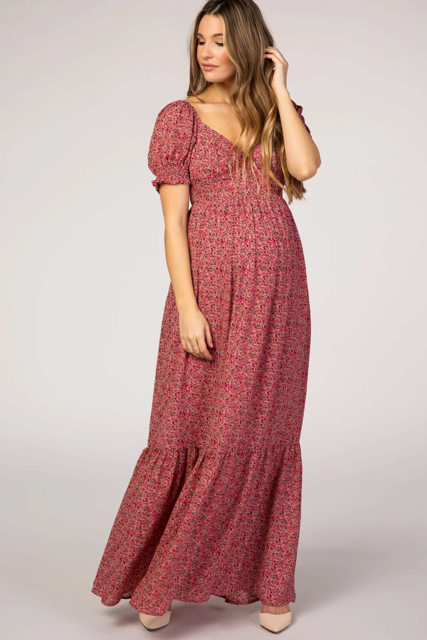 women in a pink floral floor length maternity dress
