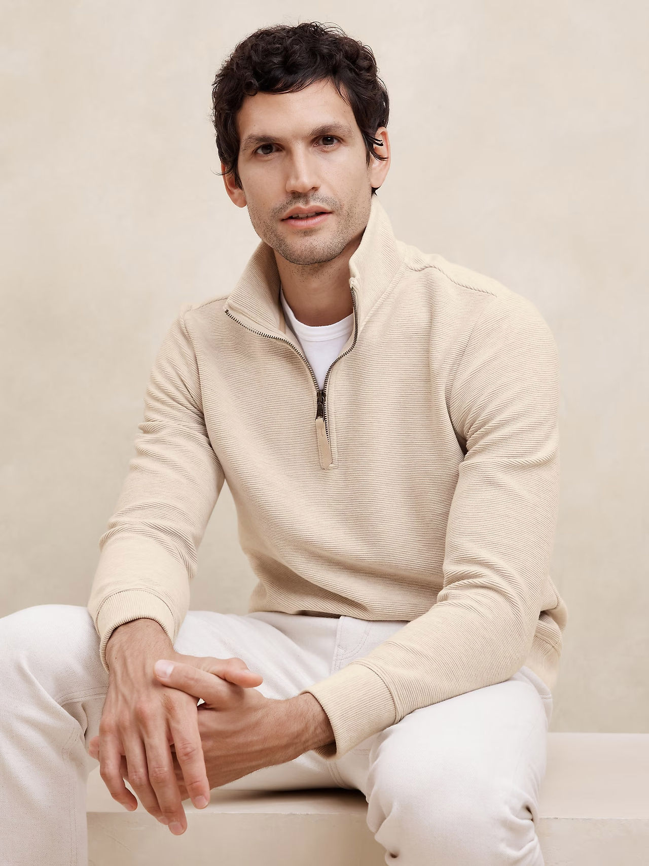 man in cream colored half zip sweater