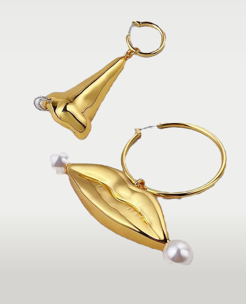 A close-up photo of Cusuti Exaggerated Gold Lip Dangle Earrings which dangle from a clasp of gold-plated environmental brass.
