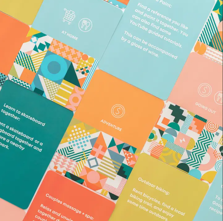 Close up of multiple date night cards laid out in a grid showing category colors, hints, and sample date prompts