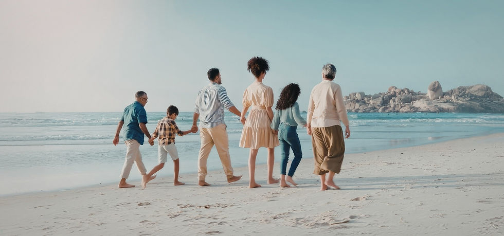 Multi-generational family walking hand-in-hand on beach