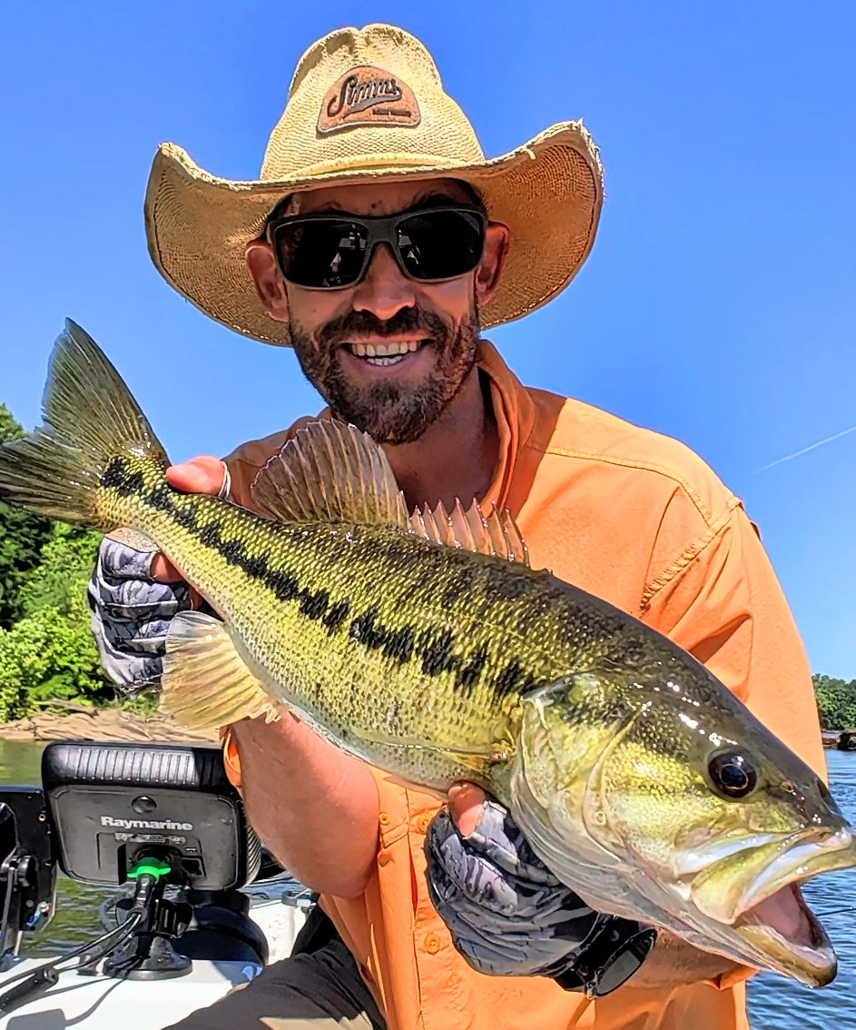 Angler holding a large Alabama bass caught fly fishing on the Coosa River in Alabama