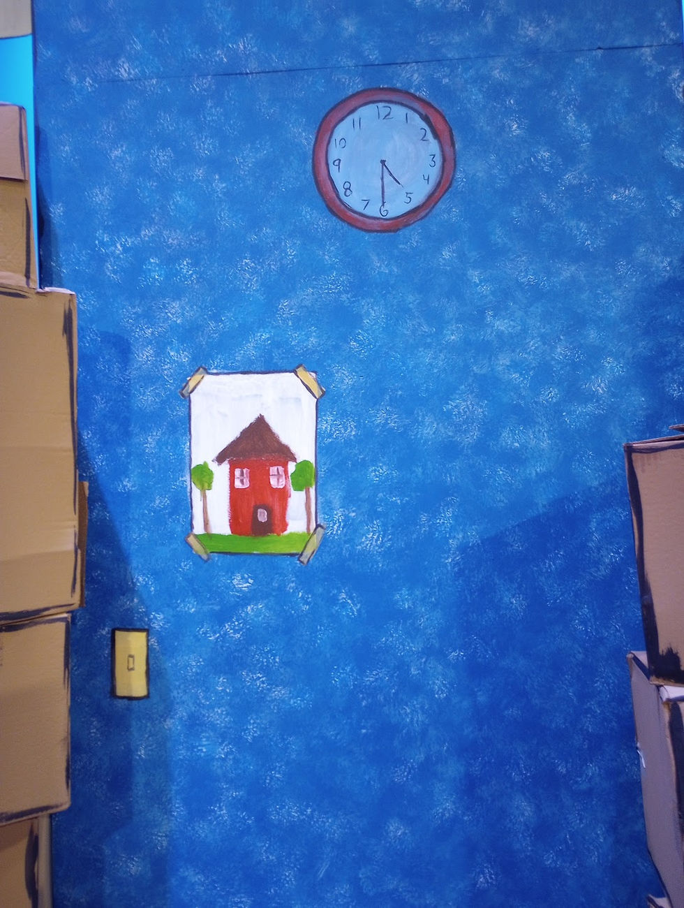 Cartoon-esque set dressing painted on the walls accompanied by a painted childlike drawing