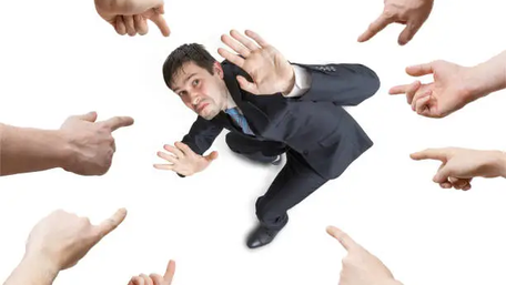 Man with fingers pointing at him as he tries to please everyone