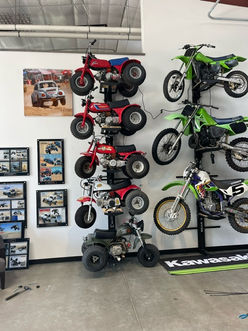 A collection of classic atc bikes and dirt bikes stored on the wall