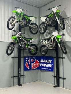 4 dirt bikes displayed on 2 wall mounted lifts.