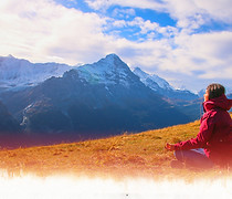 Woman meditating on mountaintop at sunrise — symbolizing Ascension Assist, a remote healing program for ongoing energy clearing, spiritual evolution, and sustained energetic alignment
