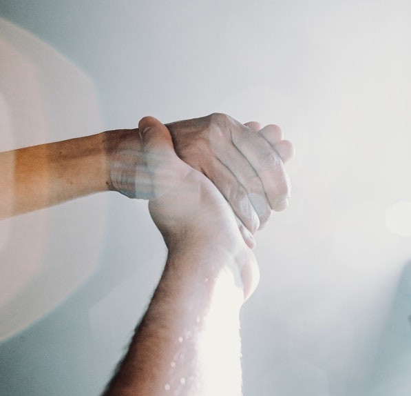 two hands holding over sparkling background