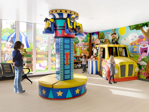 Carnival-Themed Indoor Play Area: A playful indoor area with carnival-themed elements, including a rotating seat structure and a colorful play bus, designed for kids to enjoy a carnival-inspired adventure.