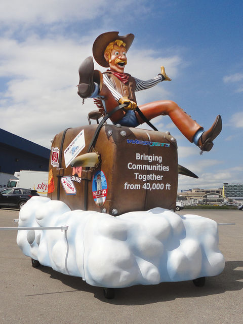 WestJet Parade Float: A cowboy-themed float with a large, animated cowboy riding on a suitcase among clouds, promoting WestJet’s high-altitude travel with the tagline “Bringing Communities Together from 40,000 ft.”