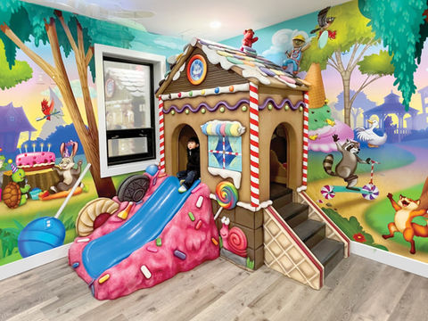 Candyland-Themed Play Area: A colorful candy-themed play structure with a gingerbread house, ice cream cones, and candy decorations, creating a playful and whimsical experience for children.