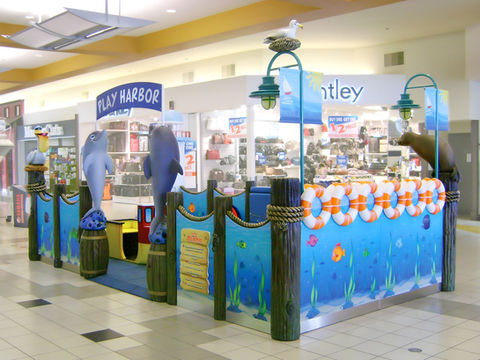 Play Harbor Themed Play Area: A harbor-themed play area featuring sea animals like dolphins and sea lions, complete with lifebuoys and nautical-themed elements, creating an inviting play space for children.