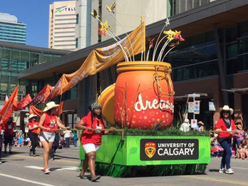 University of Calgary Dream Jar Float: A bright and creative float for the University of Calgary, showcasing a giant jar labeled “Dreams” filled with colorful stars and floral decorations.