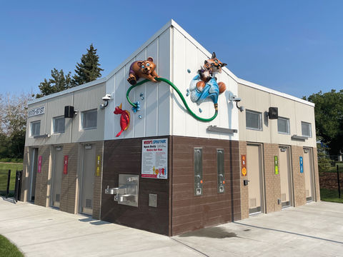 Woody’s Spray Park Signage: Playful characters, including a bear and fox, climb around the exterior of the shower facility, adding an engaging and child-friendly element to a water park.