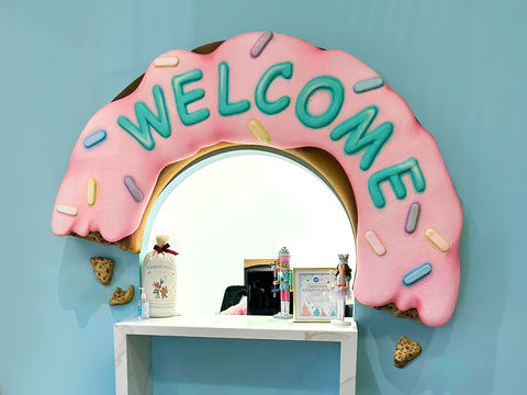 Welcome Donut Sign: A whimsical welcome sign in the shape of a pink frosted donut with colorful sprinkles, adding a sweet and playful touch to the entrance.