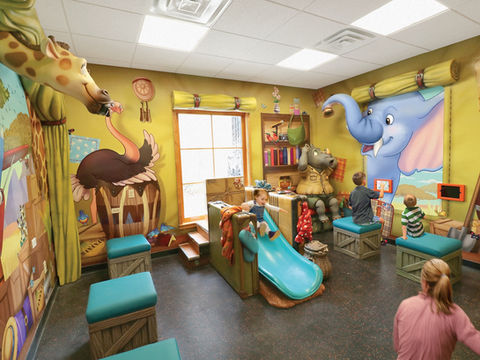 Safari-Themed Play Room with Slide: A jungle-themed play area with cartoon animal murals, featuring a slide and seating area, designed to create a fun and educational atmosphere for children.