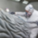 Image of a worker spray painting a large sculpture – A worker in protective gear spray-painting fine textures on a themed sculpture, giving depth and realism to the large piece.