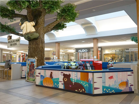 Woodland Play Area with Tree and Animals: A woodland-themed play area featuring a large artificial tree with raccoons, squirrels, and other animals, welcoming children into an engaging and nature-inspired play zone.