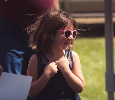 a little girl wearing pink sunglasses and a blue dress