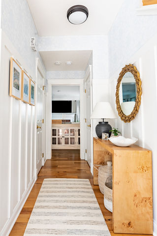 entry way with custom board and batten and light blue wallpaper, console table with gold leaf mirror above