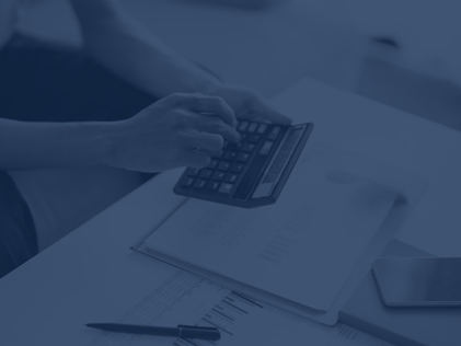 Mãos mexendo em calculadora e papéis.