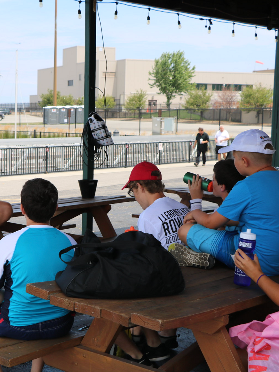 Instructor talks to children at a sailing camp by the marina.