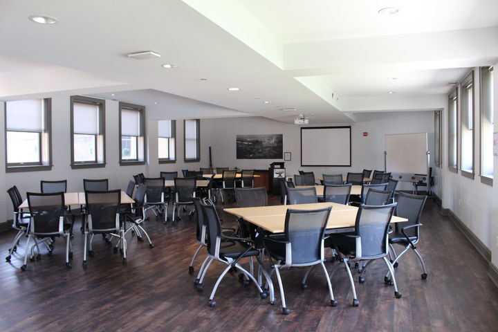 Meeting room with tables, chairs, and projector screen