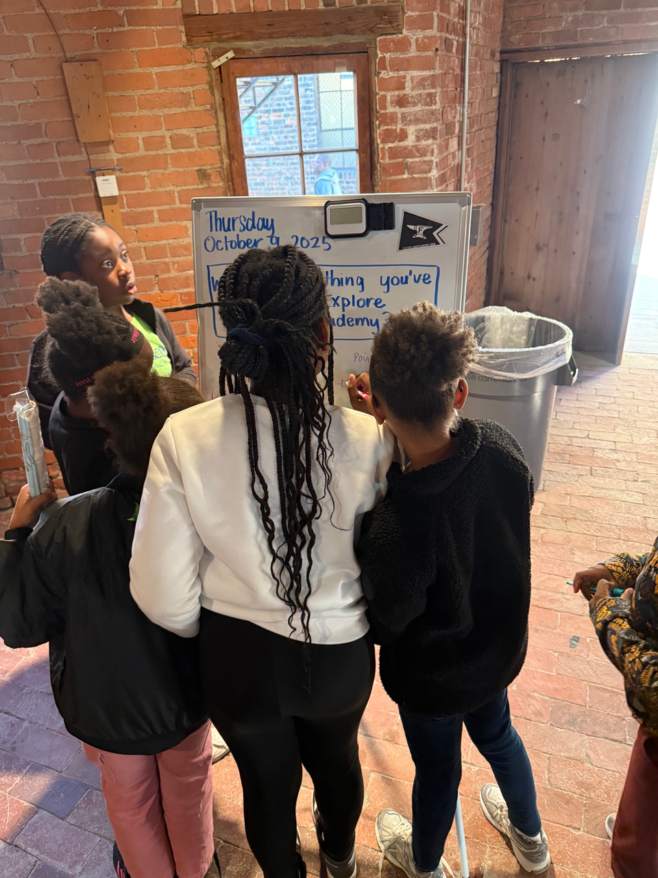 Adult leading children at a whiteboard