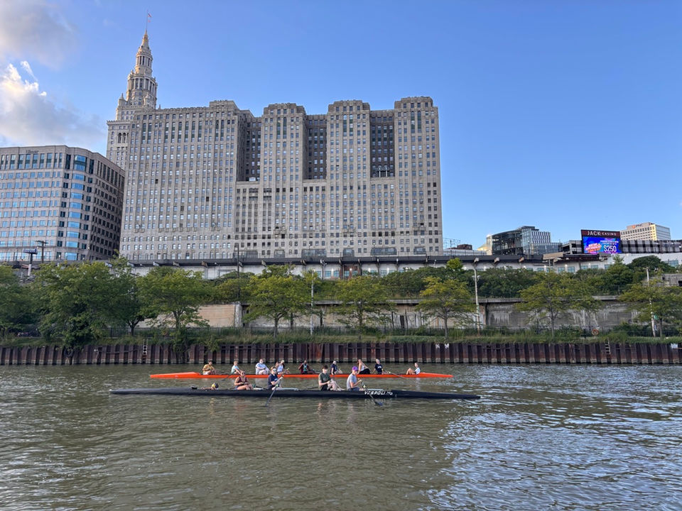 Rowing team on a river with city skyline