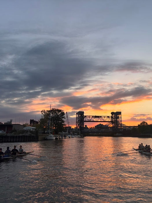 Rowers on a river at sunset