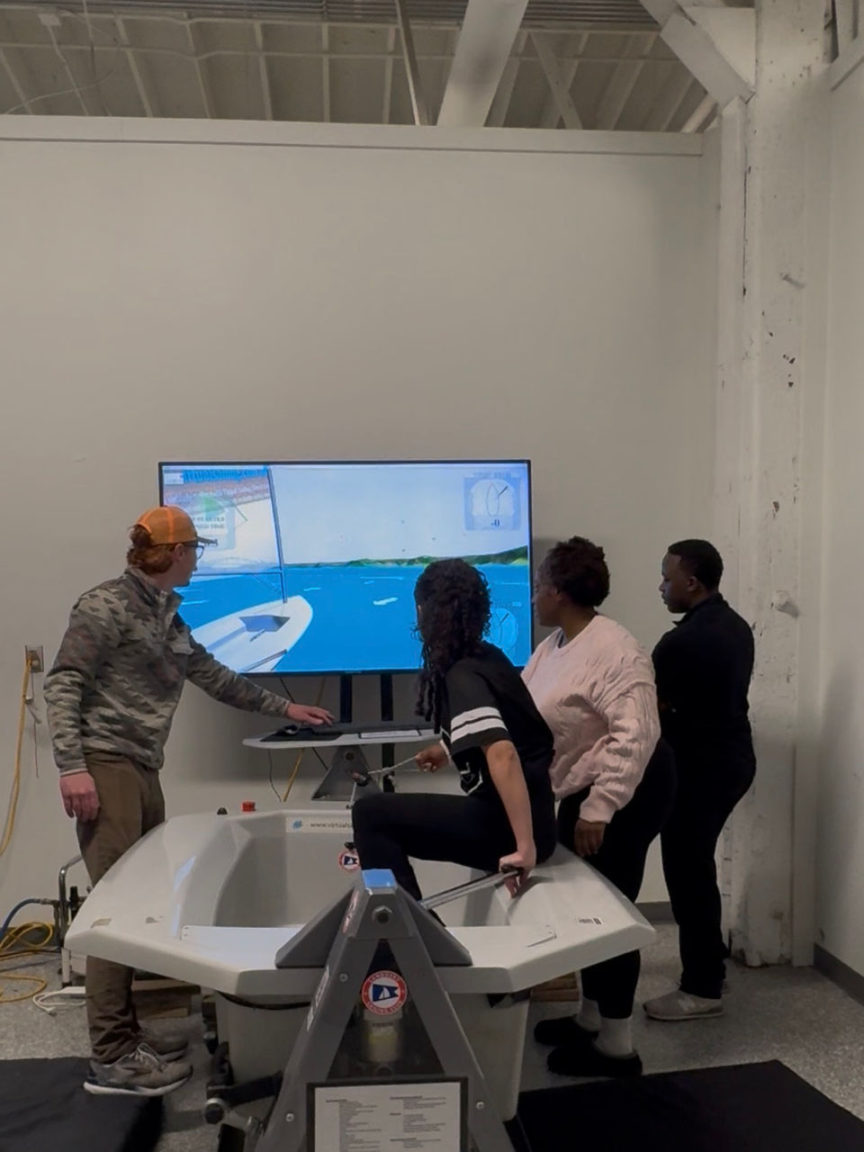 Instructor and students at a sailing simulator