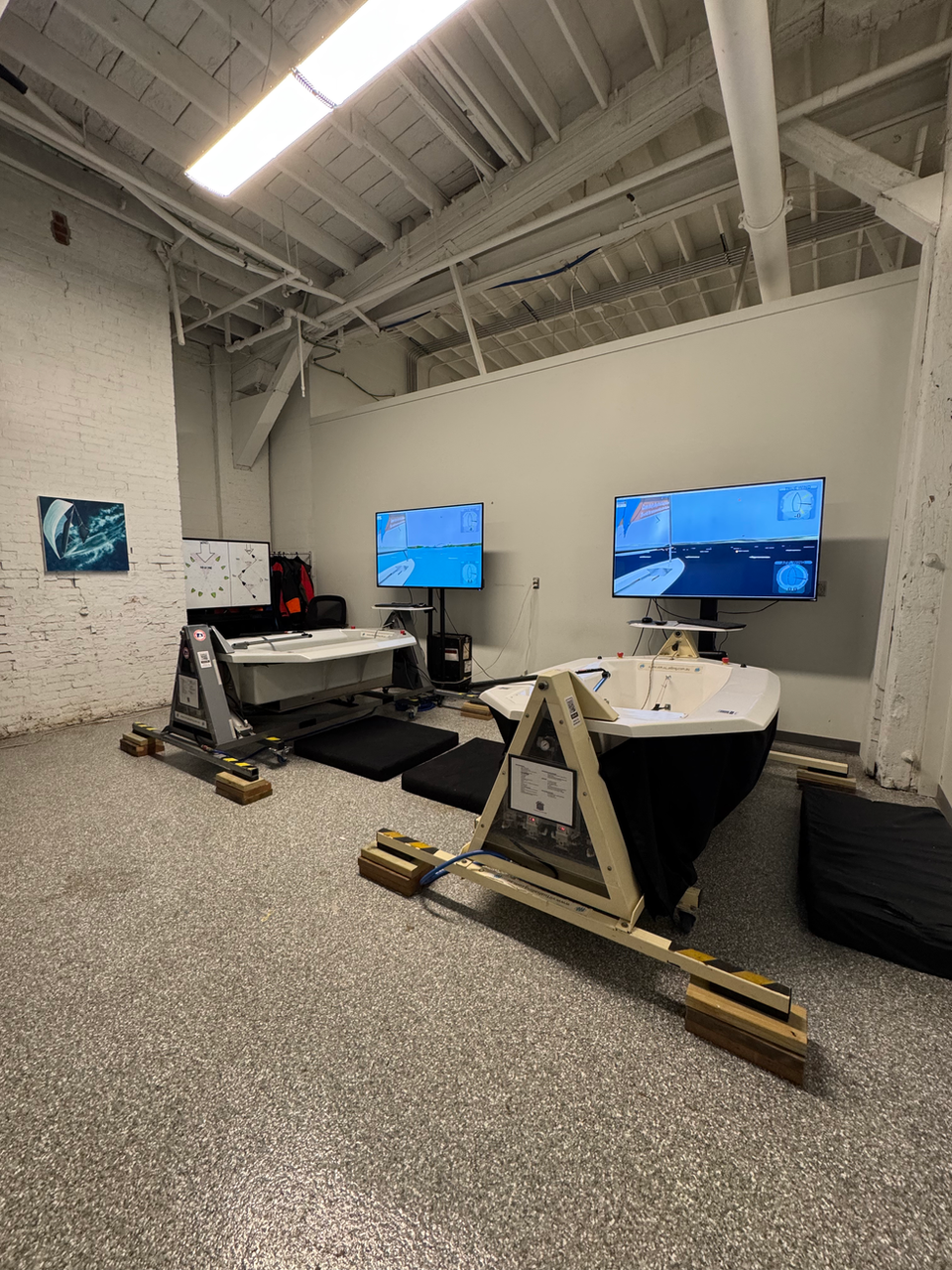 Two sailing simulator stations with large display screens.