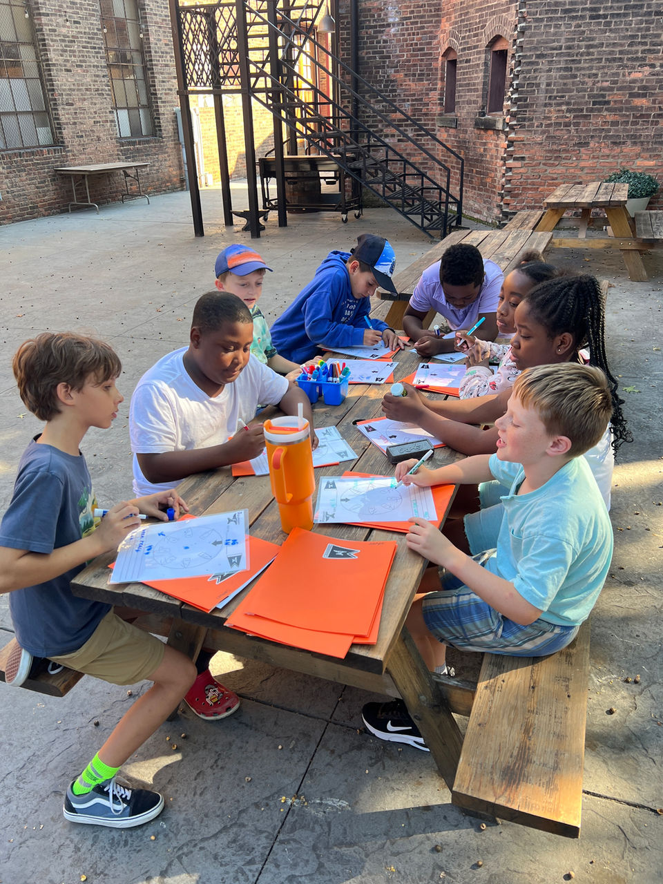 Children learning at an outdoor picnic table