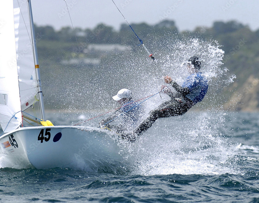 Sailboat with two people splashing through water