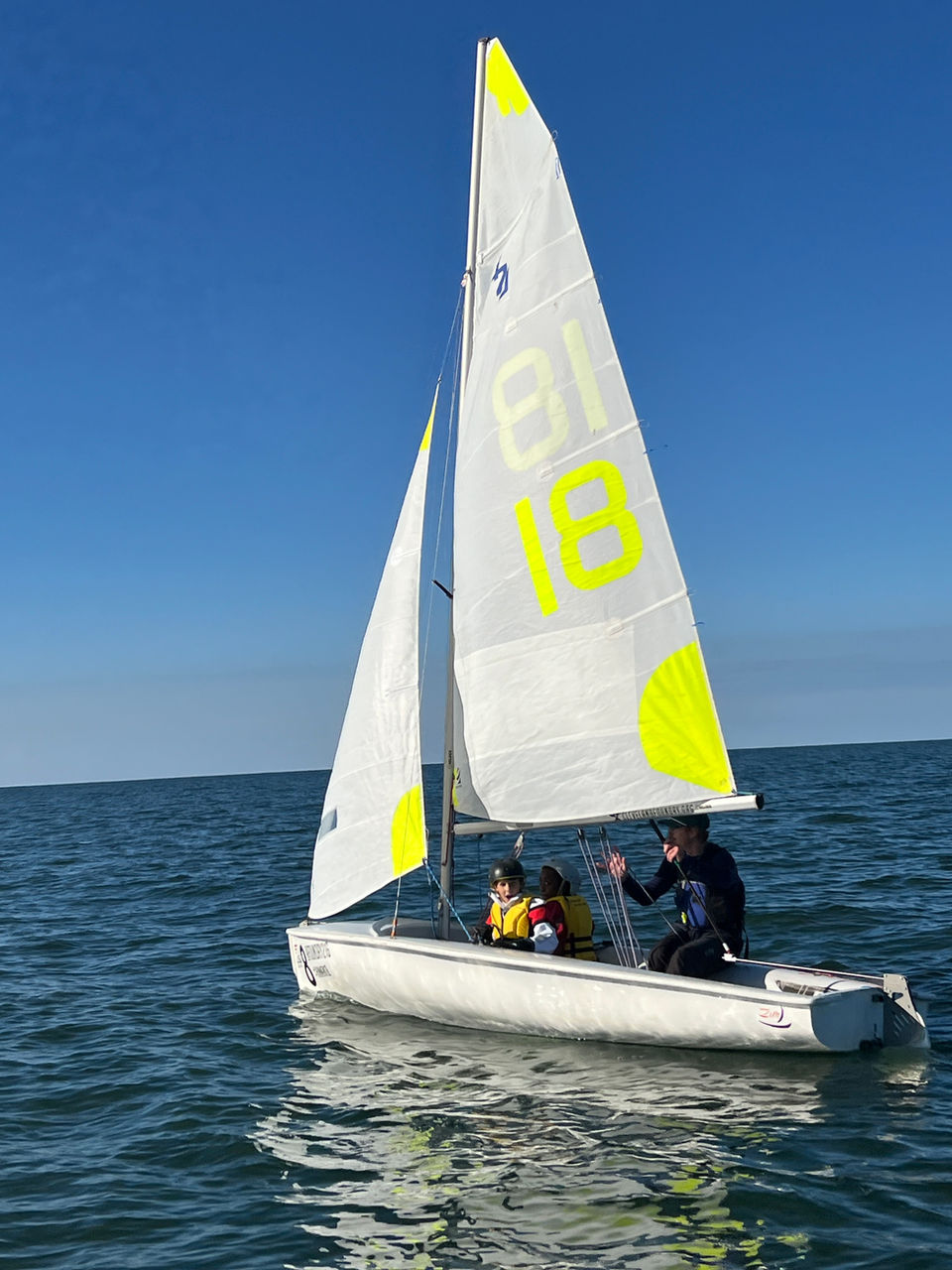 Two people sailing a small boat on calm water