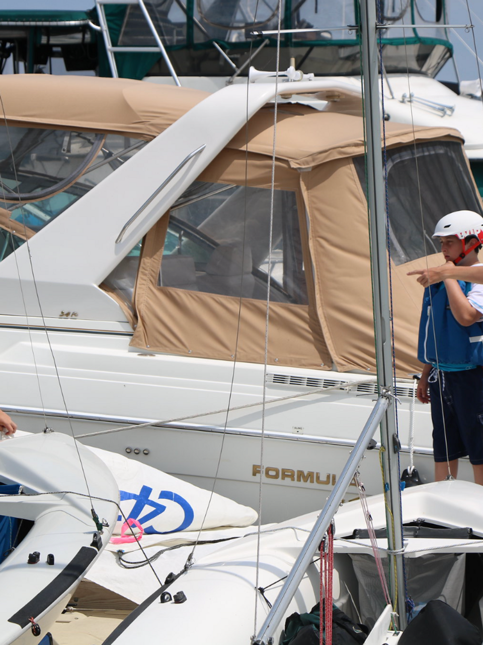 Two boys at sailing camp with dinghies