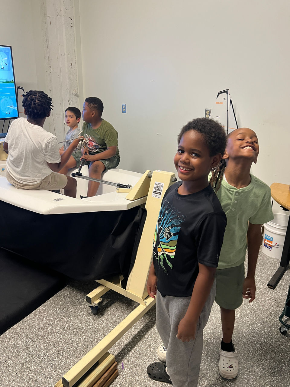 Two boys smiling in a simulator room