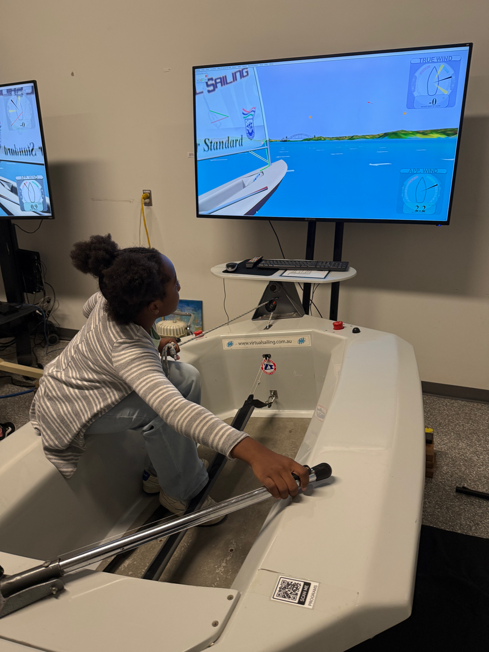 Student practicing sailing in a boat simulator