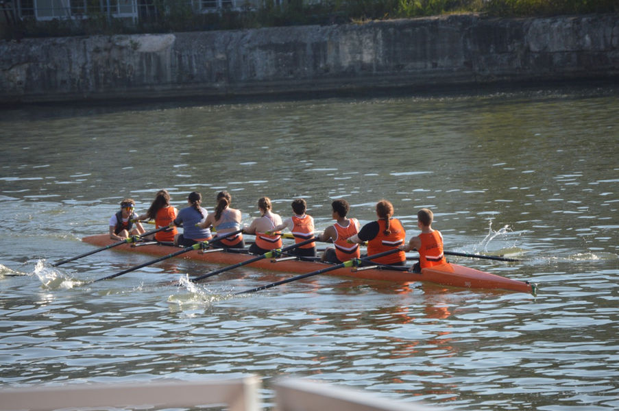 Eight people rowing in a crew shell on the water