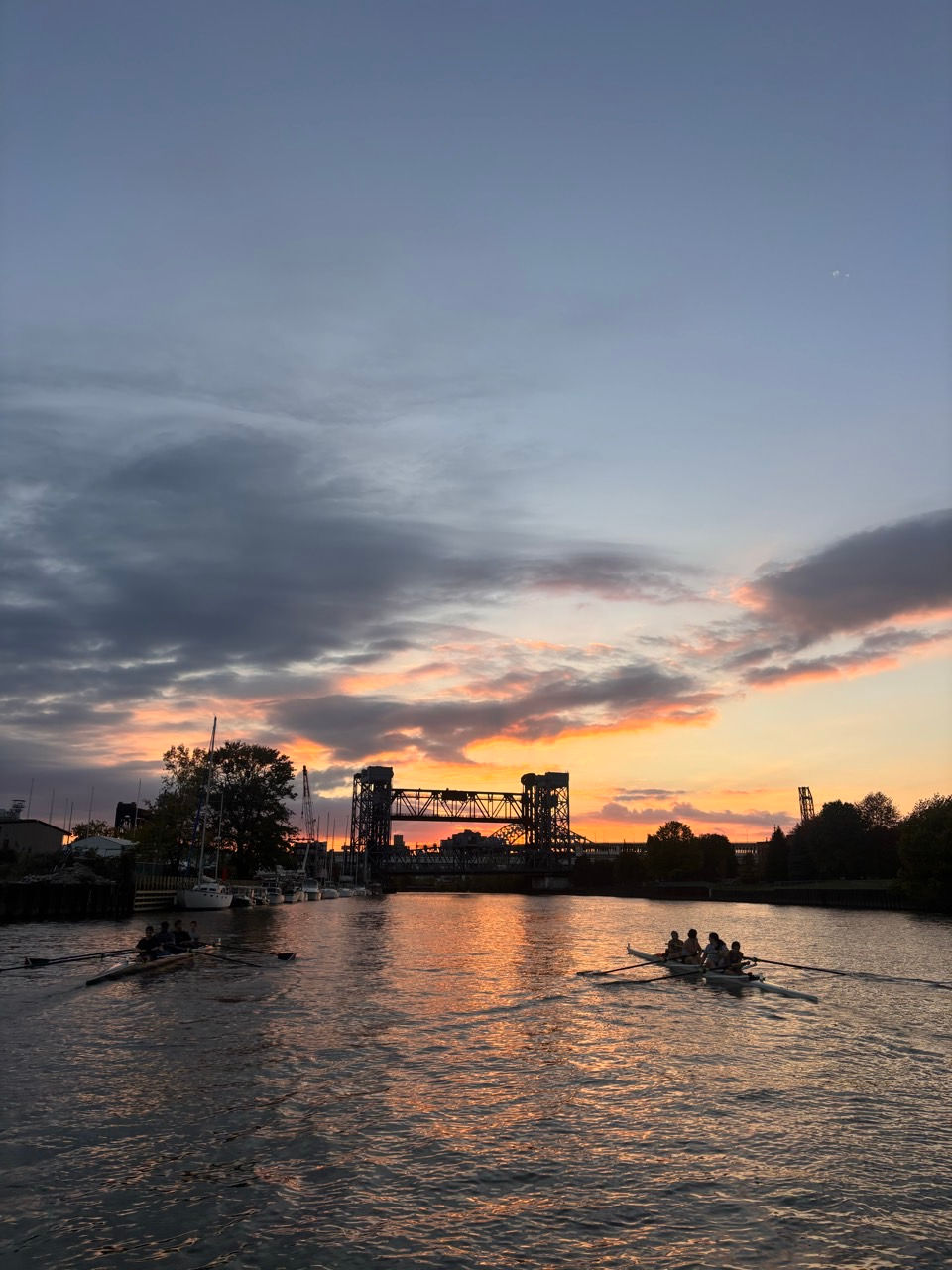 Sunset over river with bridge and boats