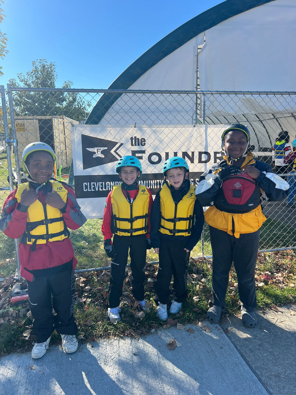 Four children in life jackets and helmets at a Sailing Academy