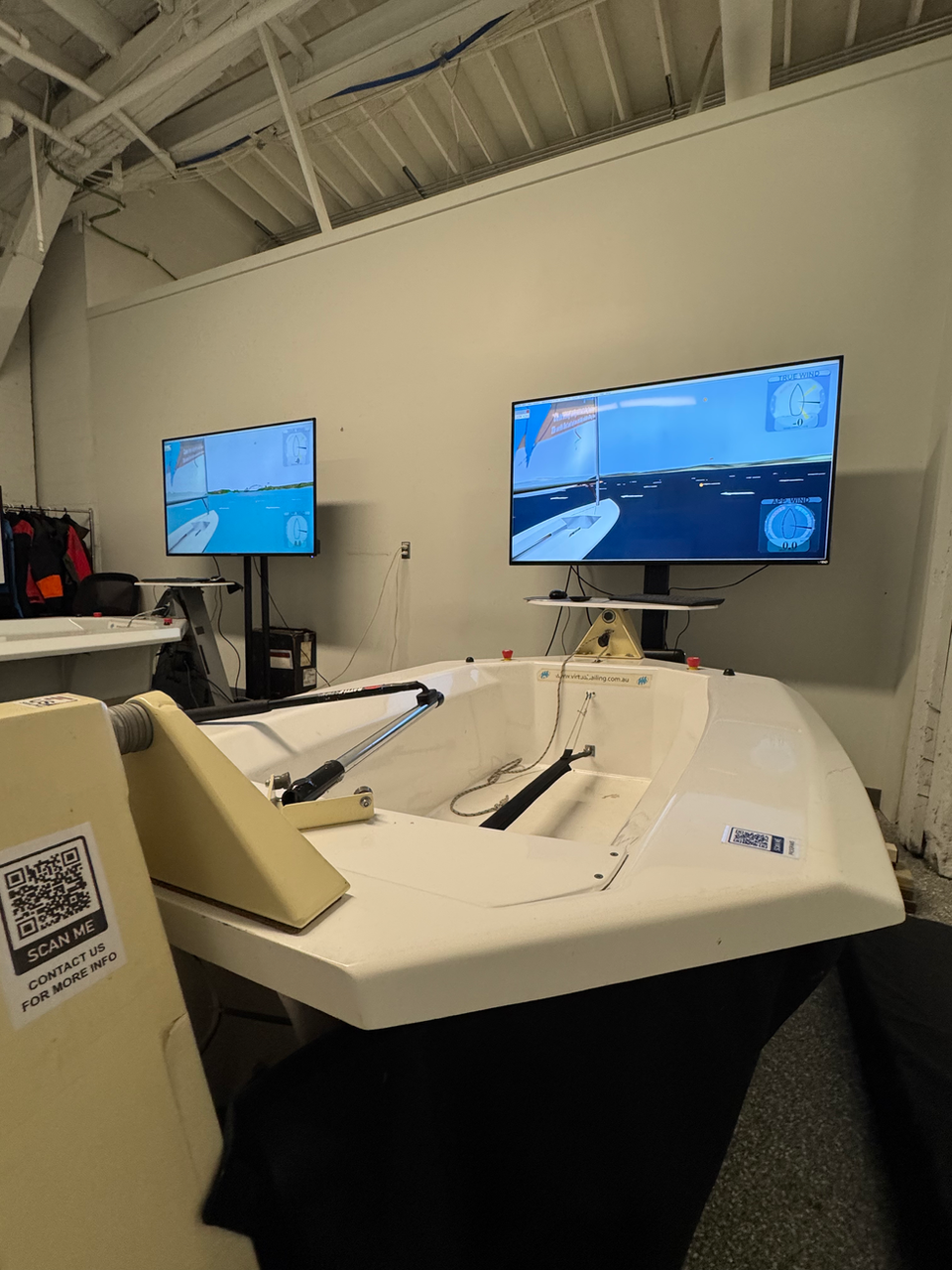 Two sailing simulators with screens showing boats on the water